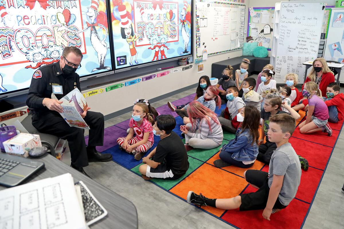 Fire Chief Scott Haberle, far left, reads "Dragons Love Tacos" to first-graders in Christine Netter's classroom on Wednesday.