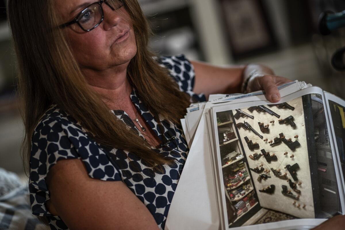 Janet Paulsen muestra una foto de algunas de las docenas de armas que la policía incautó a su esposo 