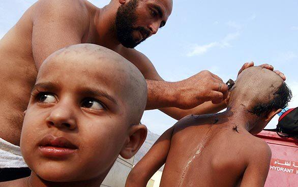 A pilgrim shaves the heads of his sons as part of the rituals during the hajj, the pilgrimage to Mecca, Saudi Arabia, that is required of able-bodied Muslims at least once in their lifetime. The official Saudi Press Agency reported that the total number of pilgrims this year was more than 2.4 million, with almost 1.73 million from abroad.