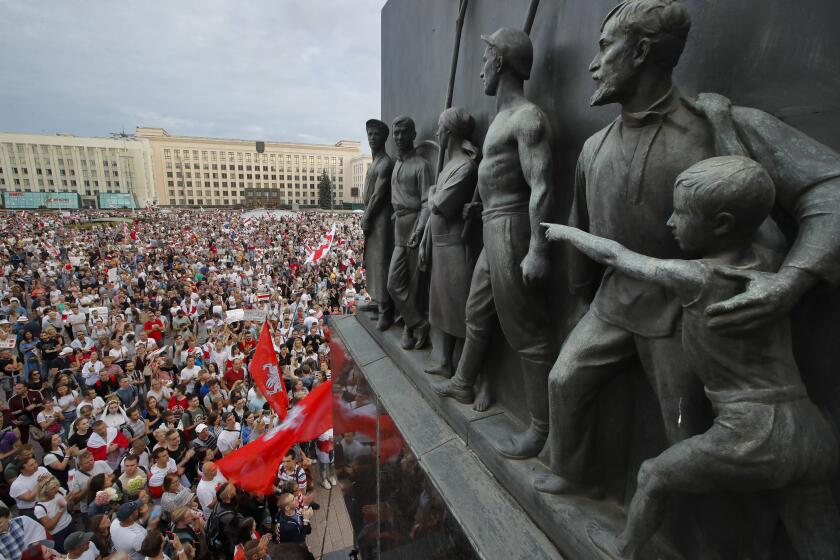 FILE - In this Tuesday, Aug. 18, 2020 file photo Belarusian opposition supporters gather for a protest rally in front of the government building at Independent Square in Minsk, Belarus, with a Soviet era sculptures in the foreground. European Union leaders are putting on a show of support Wednesday Aug. 19, 2020 for people protesting in Belarus. Emergency talks will aim to highlight their concern about the contested presidential election and ratchet up pressure on officials linked to the security crackdown that followed. The EU believes that the results of the Aug. 9 polls, which handed President Alexander Lukashenko his sixth term with 80% of the vote, "have been falsified," and the 27-nation bloc is preparing a list of Belarus officials who could be blacklisted from Europe over their roles. (AP Photo/Dmitri Lovetsky, File)