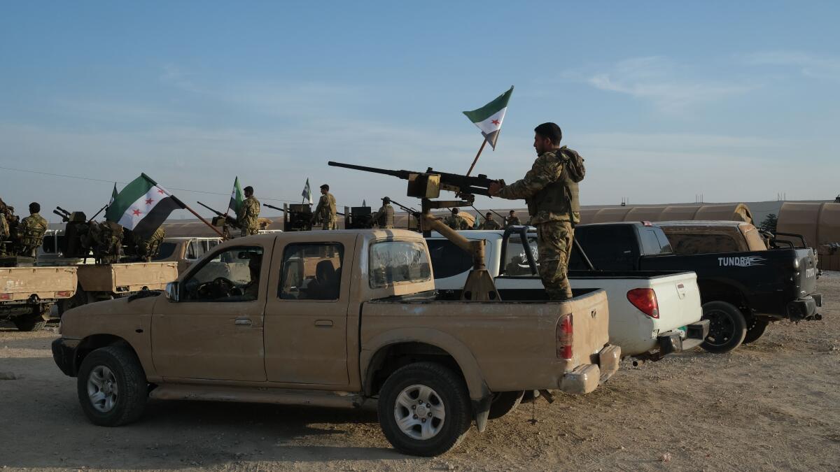 Members of the Kurdish People’s Protection Units, or YPG, hold a position Oct. 8 on a building in the Syrian town of Tel Abyad. 