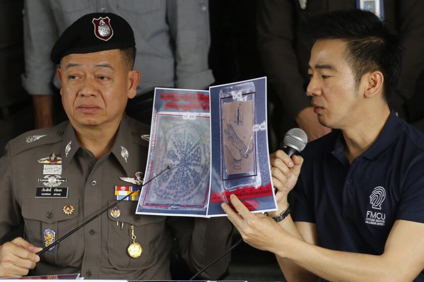 Thai police officers show pictures of a tattooed human skin during a news conference in Bangkok. Two pieces of skin and three other body parts were found in three packages bound for the United States.