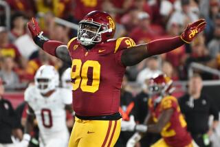 USC defensive lineman Bear Alexander celebrates after tipping a Stanford pass during a game at the Coliseum 