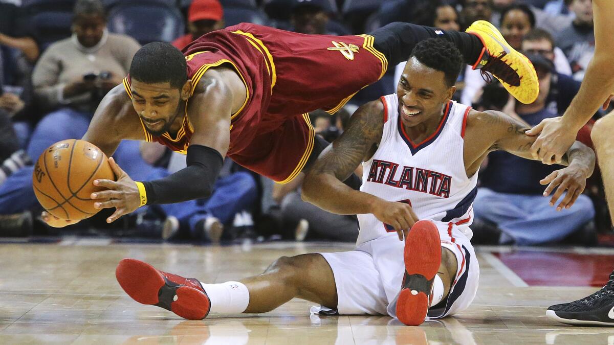 Cleveland Cavaliers guard Kyrie Irving, left, dives for a loose ball in front of Atlanta Hawks guard Jeff Teague during the Hawks' 109-101 win Tuesday.