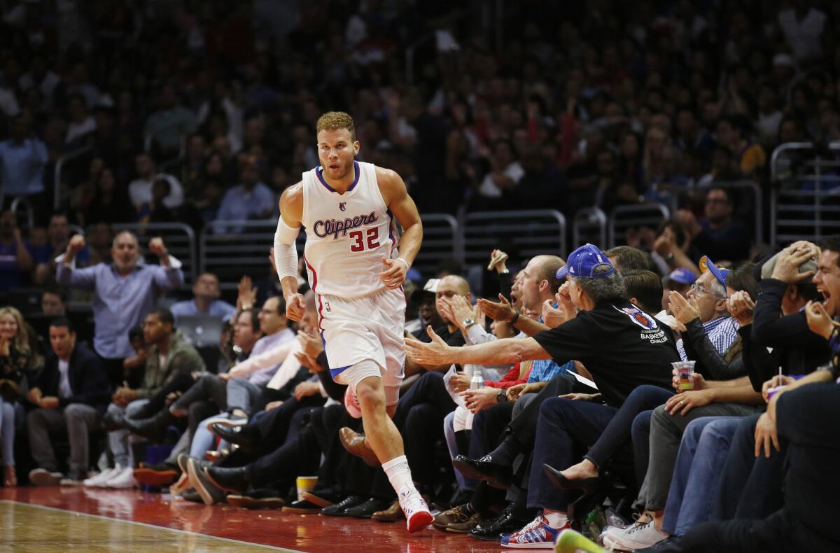 Clippers fans sitting courtside at Staples Center try to give All-Star forward Blake Griffin five after he scored against the Warriors in the second half of their game Tuesday night.