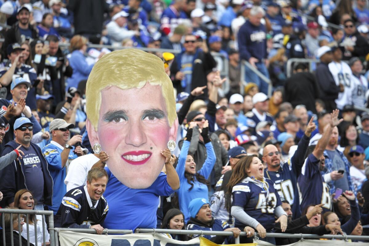 A Chargers fan holds an altered image of New York Giants quarterback Eli Manning during Sunday's game in San Diego.