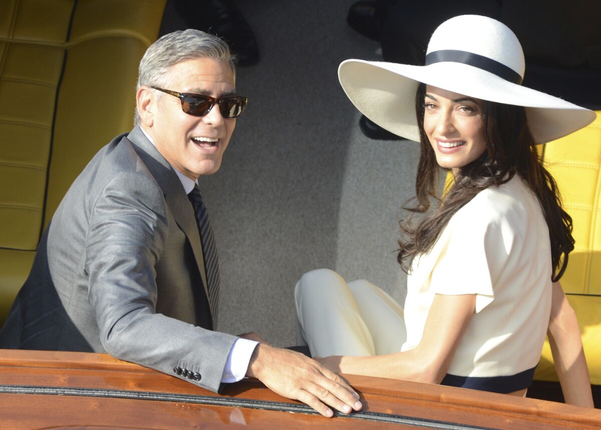 George Clooney, 53, and his new wife, Amal Alamuddin, 36, leave city hall after their civil marriage ceremony in Venice, Italy, on Monday.