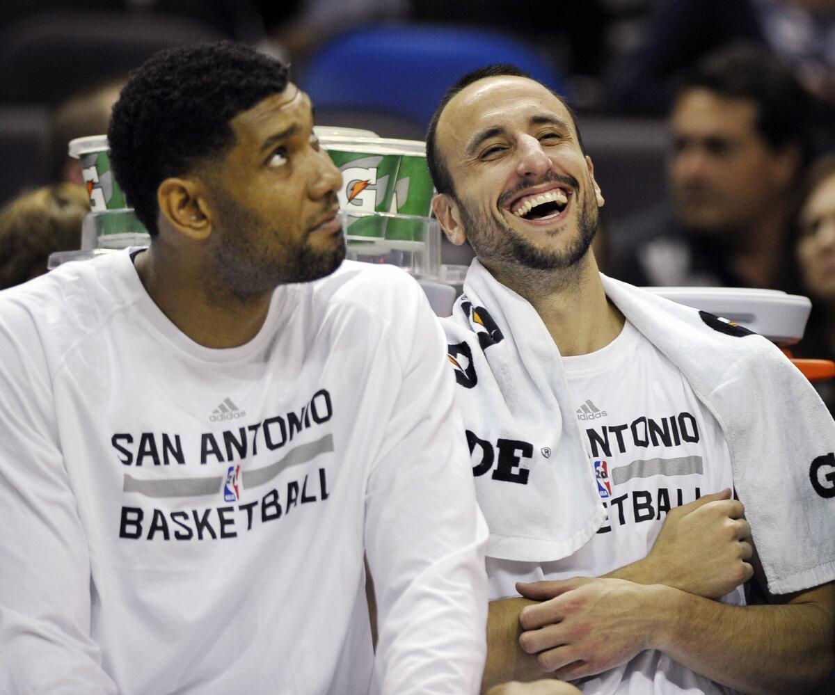 San Antonio Spurs teammates Tim Duncan, left, and Manu Ginobili share a light-hearted moment on the bench during a preseason game on Oct. 13.