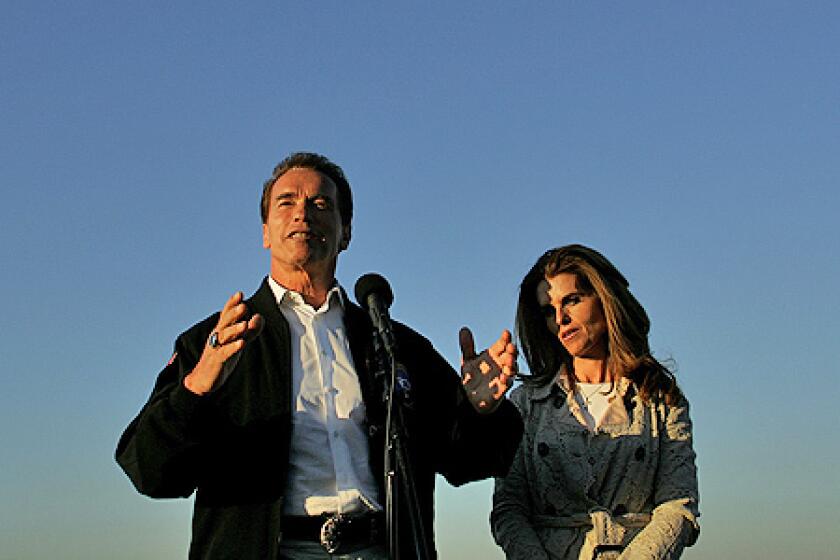 California Governor Arnold Schwarzenegger, standing next to wife Maria Shriver, addresses the media at Santa Monica Airport in November 2006.