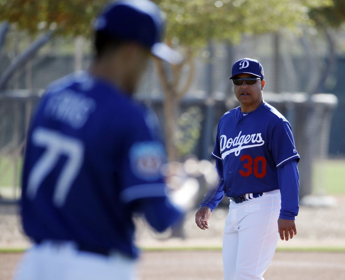 Dodgers Manager Dave Roberts watches a drill during a spring training workout on Feb. 20