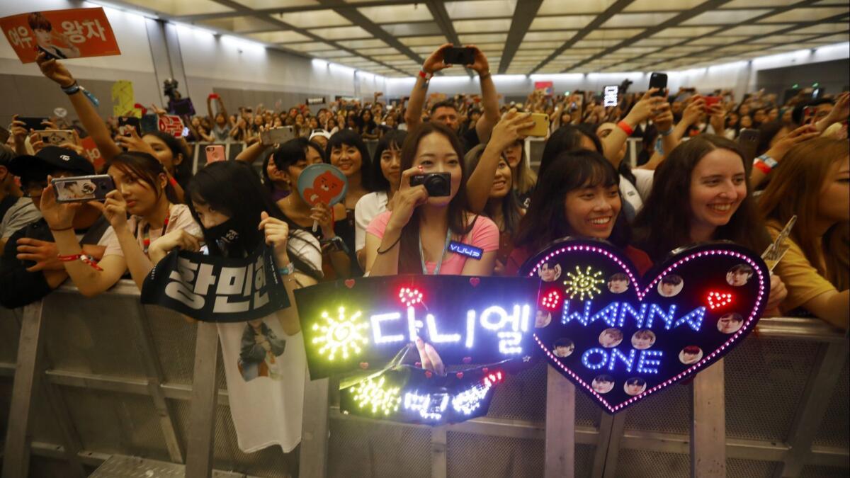 Fans react to KPOP performers arriving.