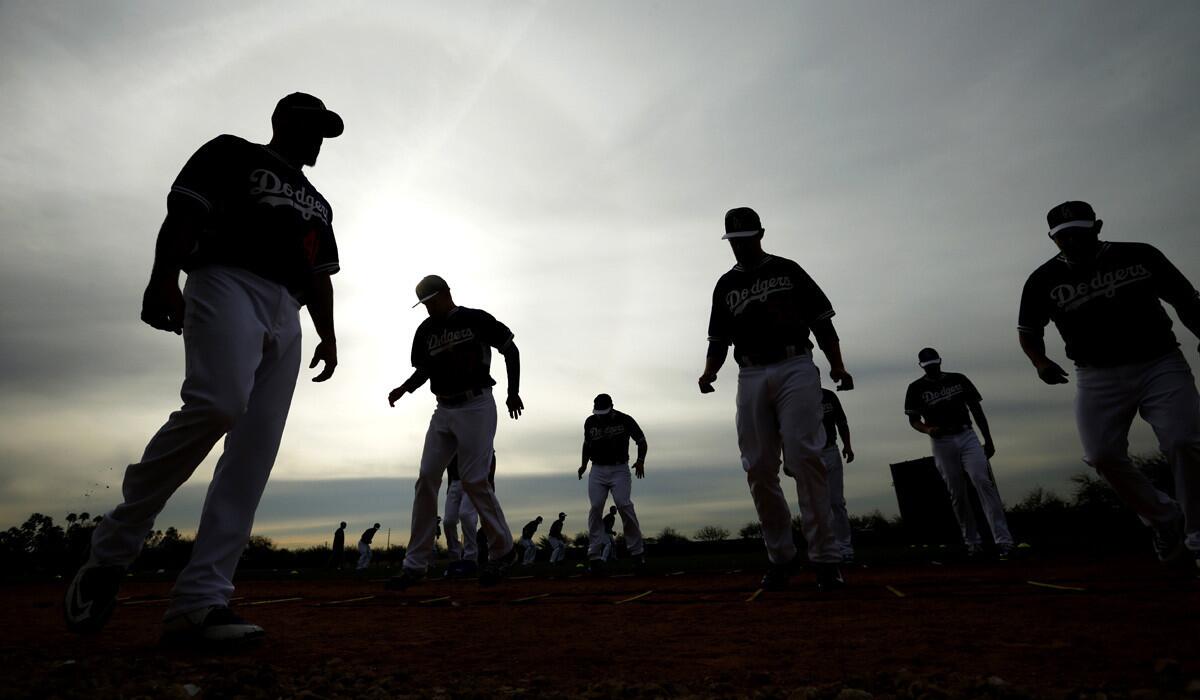 Dodgers players warm up before the team's first pitchers and catchers workout on Feb. 20.