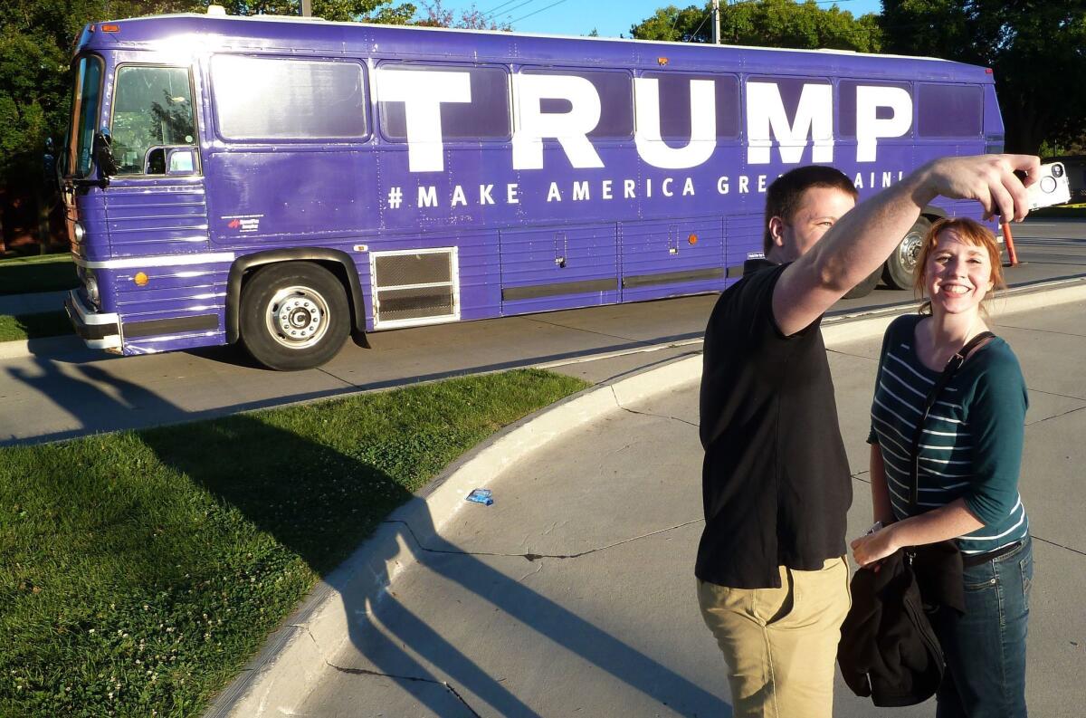 People take a photo in front of a Donald Trump's campaign bus in Urbandale, Iowa, on September 19, 2015, when it was still his campaign bus.