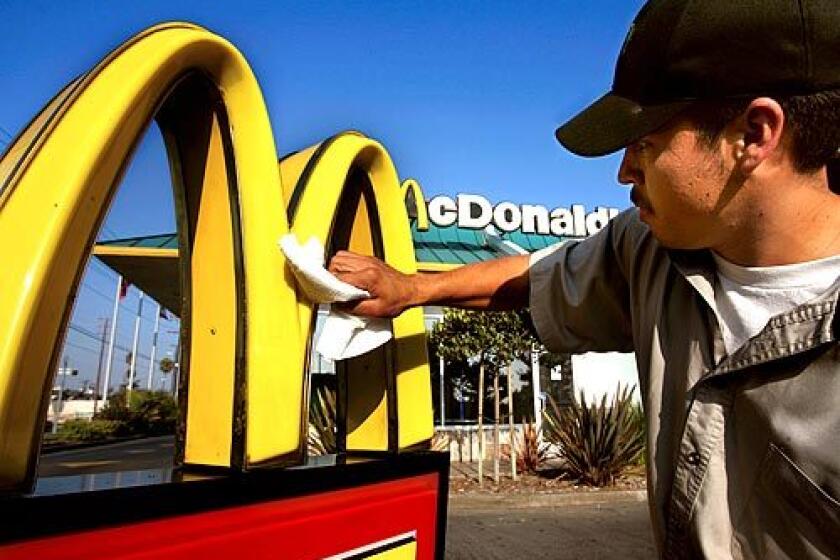 BREADWINNER: Isidro Mata, a 25-year-old McDonald's maintenance worker, polishes a sign at one of the chain's Los Angeles restaurants. Much of the money he earns he sends home to relatives in Mexico.