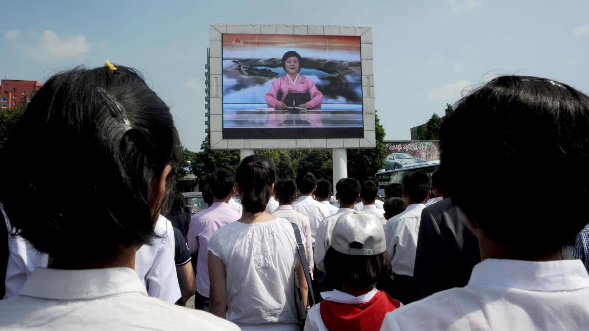 Pyongyang residents watch TV announcer Ri Chun-Hee speak about the successful launch of the intercontinental ballistic missile "Hwasong-14" on a big screen near the Pyongyang Railway Station on July 4, 2017.