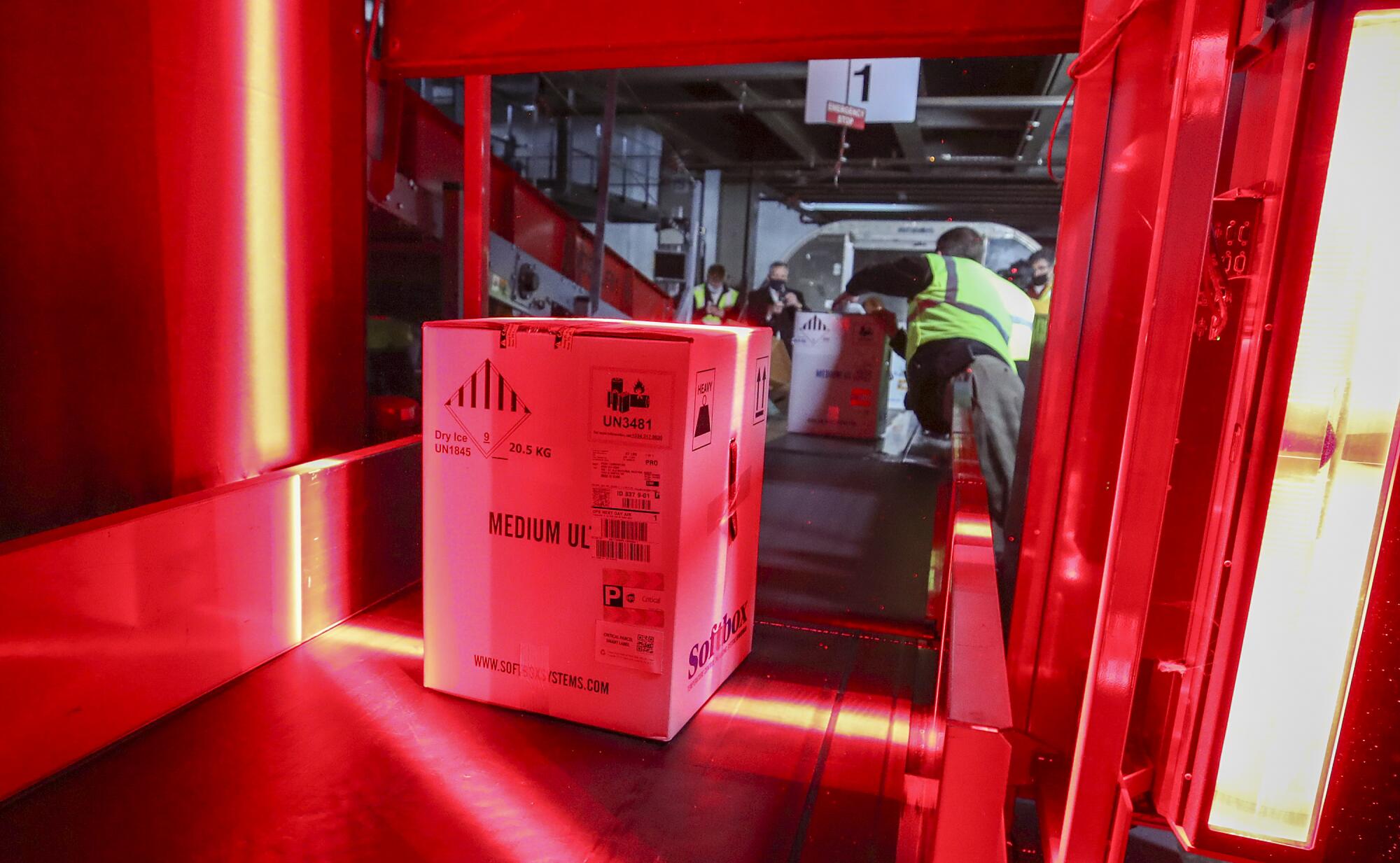 Boxes  of vaccine move on a conveyor belt 