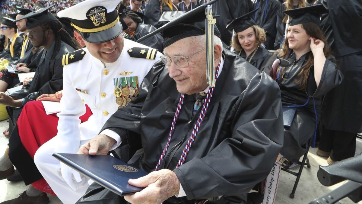 World War II veteran Bob Barger clutches his diploma at commencement exercises Saturday at the University of Toledo in Ohio.