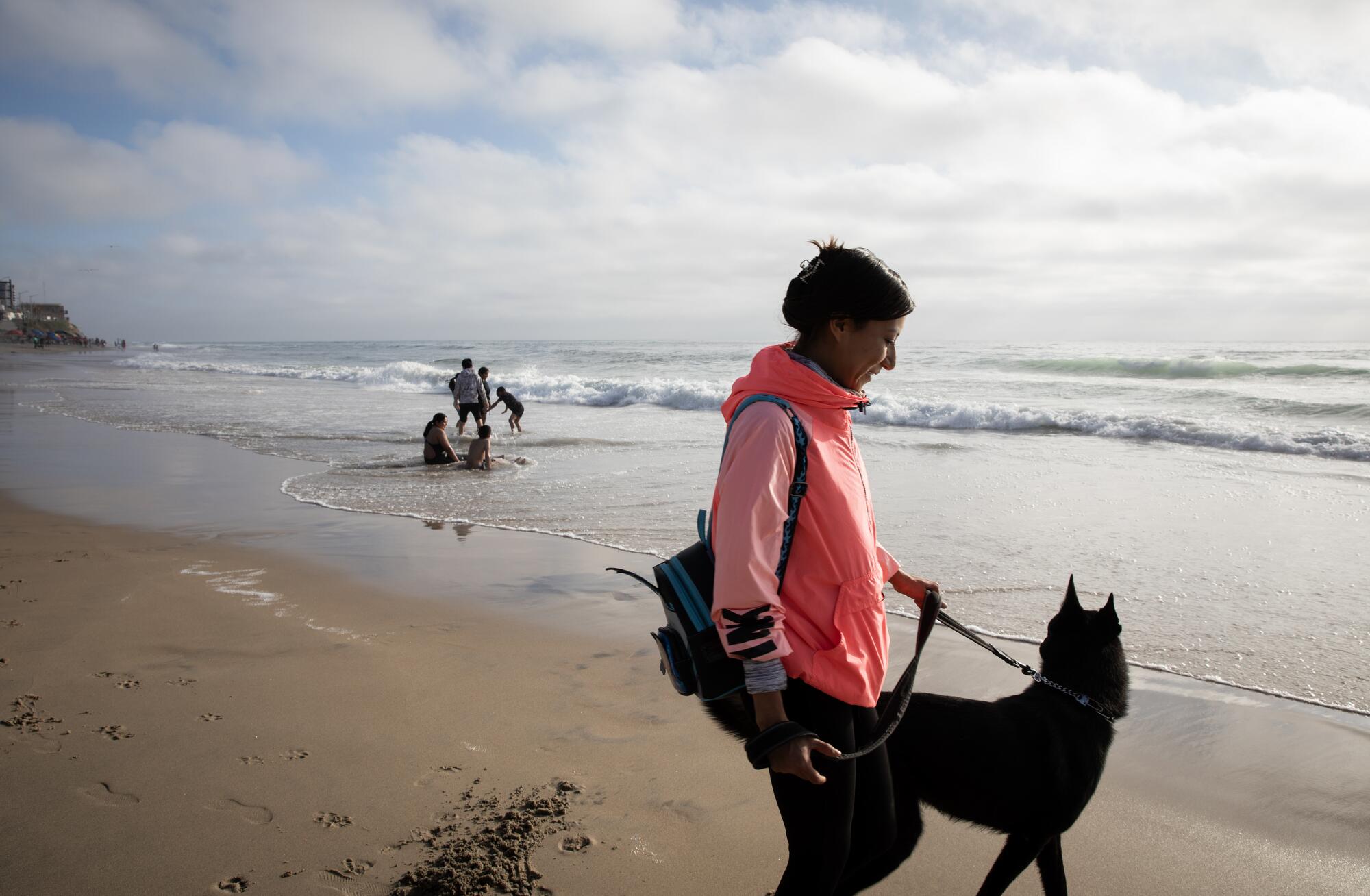 Sara Barajas walks her dog along Playas de Tijuana on April 3.