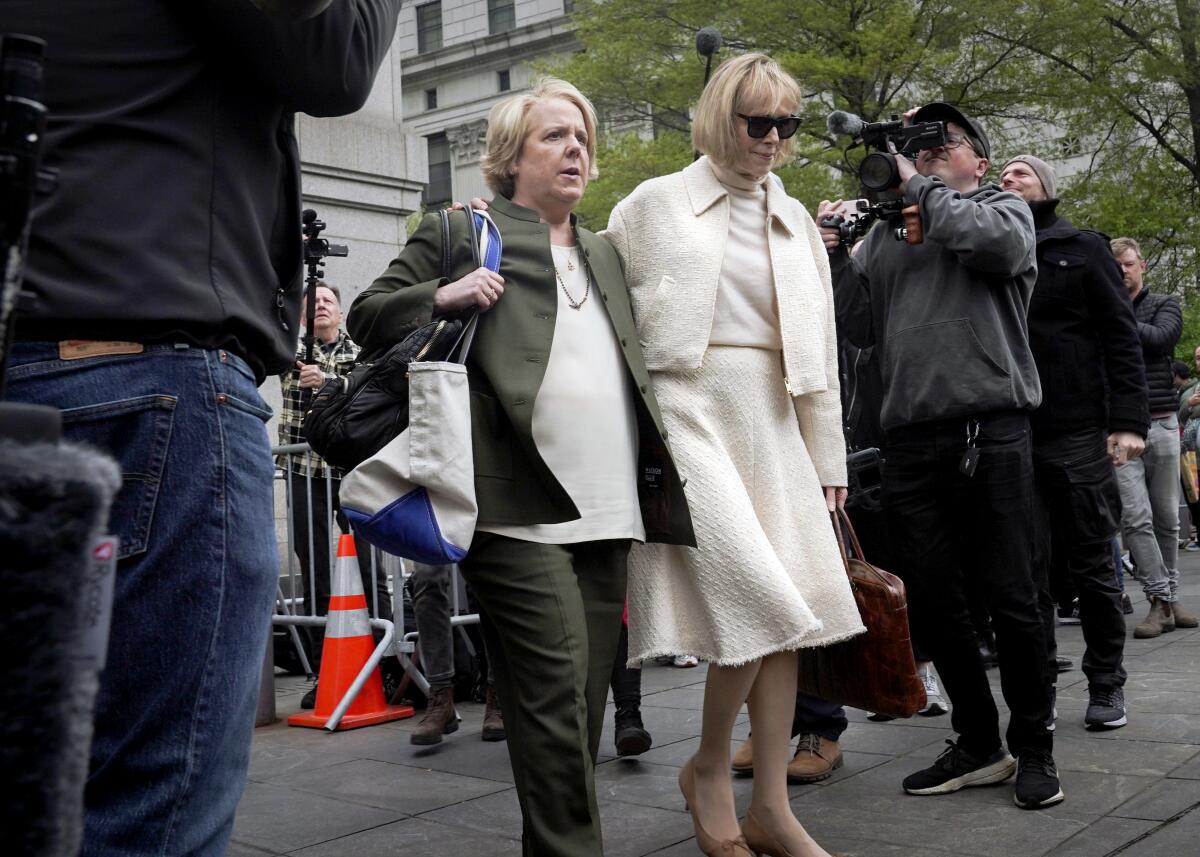 Former advice columnist E. Jean Carroll leaves court with another woman.