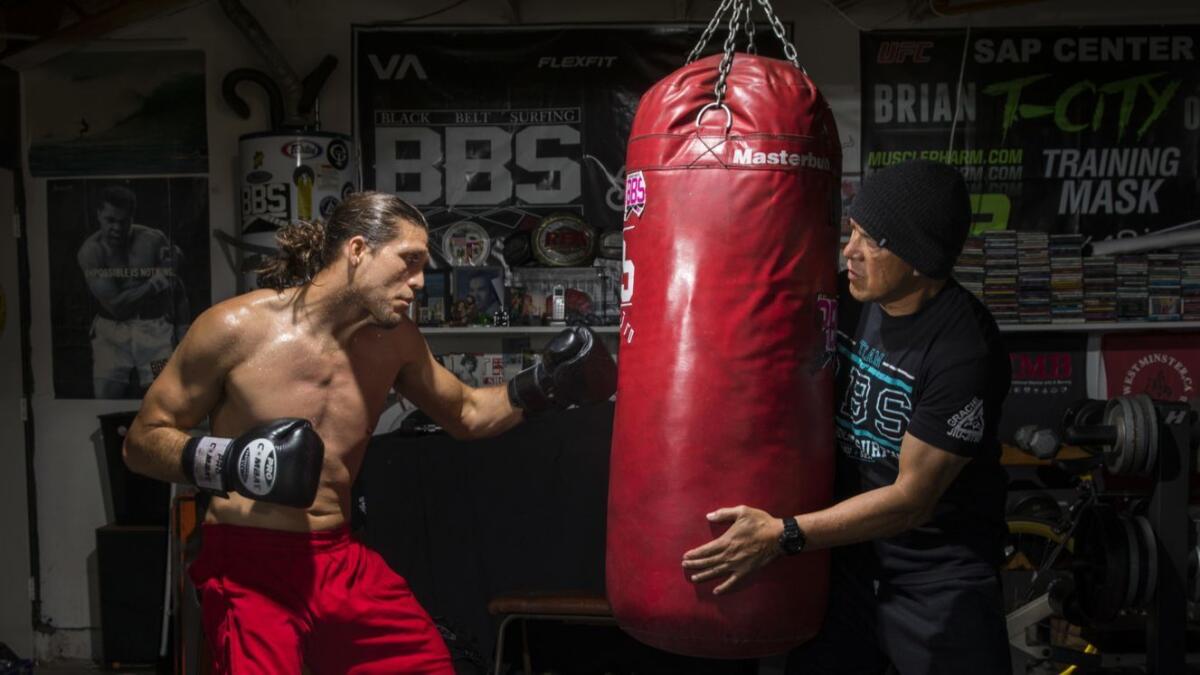 Brian Ortega, left, trains on the heavy bag.