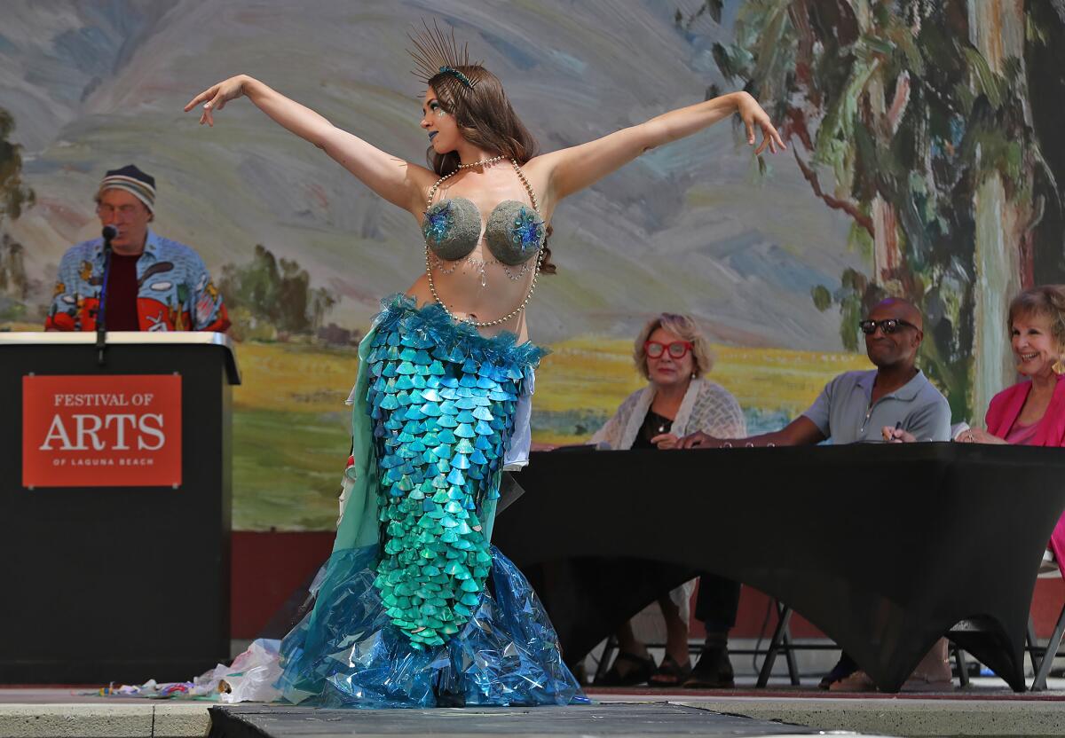 Judges admire the dress of artist Cody Nicely during the Festival of Arts runway fashion show.