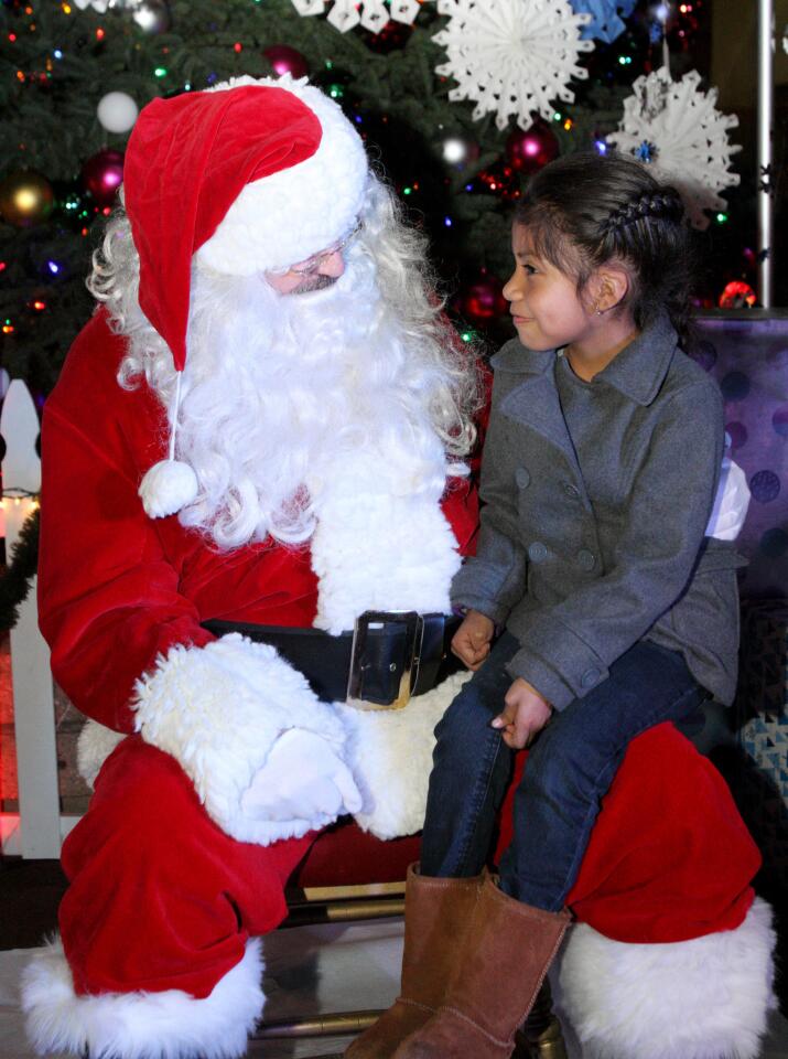 Litzy Pasan, 6, of Glendale, tells Santa Claus what she would like for Christmas after the holiday tree lighting ceremony at Perkins Plaza in Glendale on Wednesday, December 2, 2015.