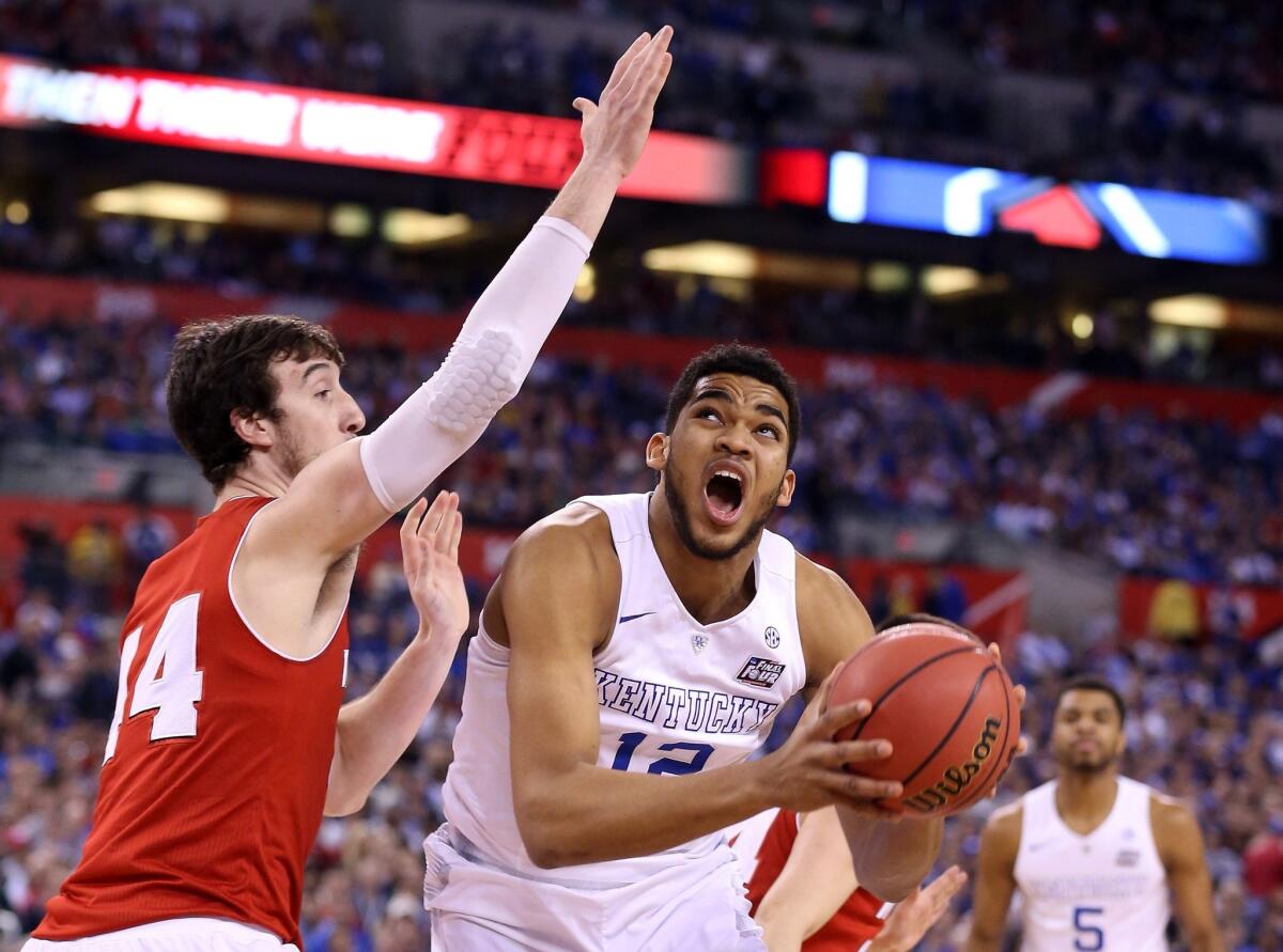 Kentucky's Karl-Anthony Towns handles the ball against Wisconsin's Frank Kaminsky during the NCAA Final Four semifinal in Indianapolis on April 4.