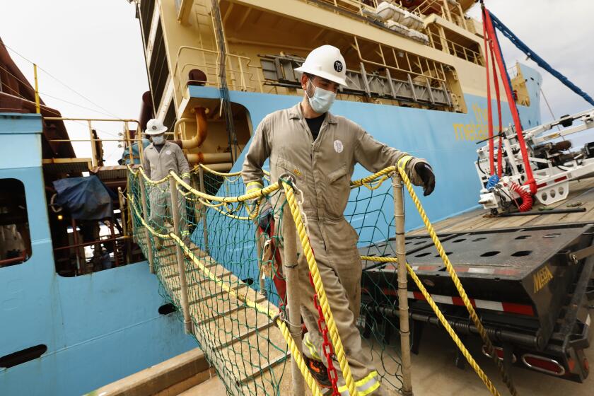 San Diego, California-June , 2021-Workers disembark from the research vessel that just returned from the Clarion Clipperton Zone of the Pacific Ocean, where soil, water, and wildlife samples were obtained from deep in the ocean as part of the research to see the effects mining will have on the environment. Gerard Barron, Chairman and CEO of The Metals Company, plans for his company to mine the seafloor for these nodules containing nickel, cobalt, and manganese in the Clarion Clipperton Zone of the Pacific Ocean. (Carolyn Cole / Los Angeles Times)