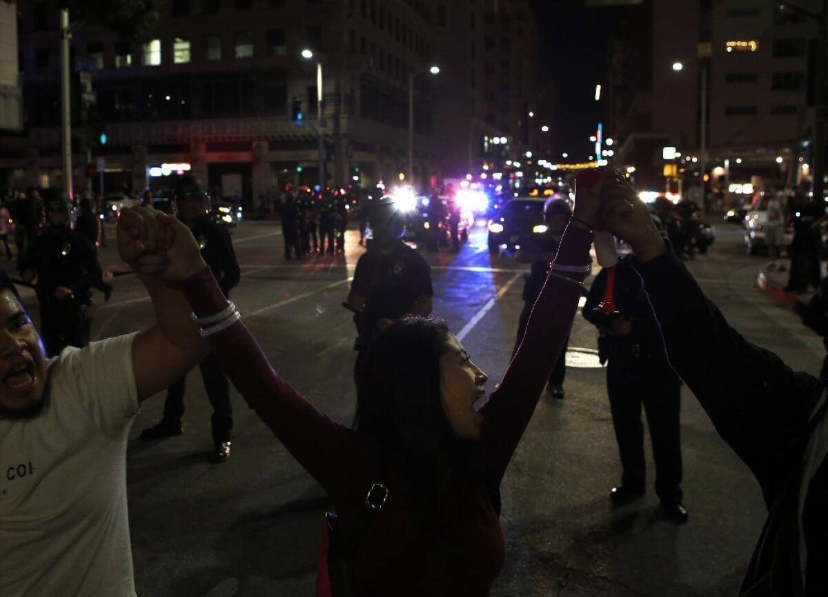 Protesters hold hands in front of police in downtown Los Angeles on Saturday night during a protest against President-elect Donald Trump.