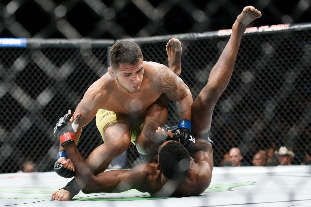 Rafael Dos Anjos takes down Neil Magny before submitting him in the first round of their fight at UFC 215.
