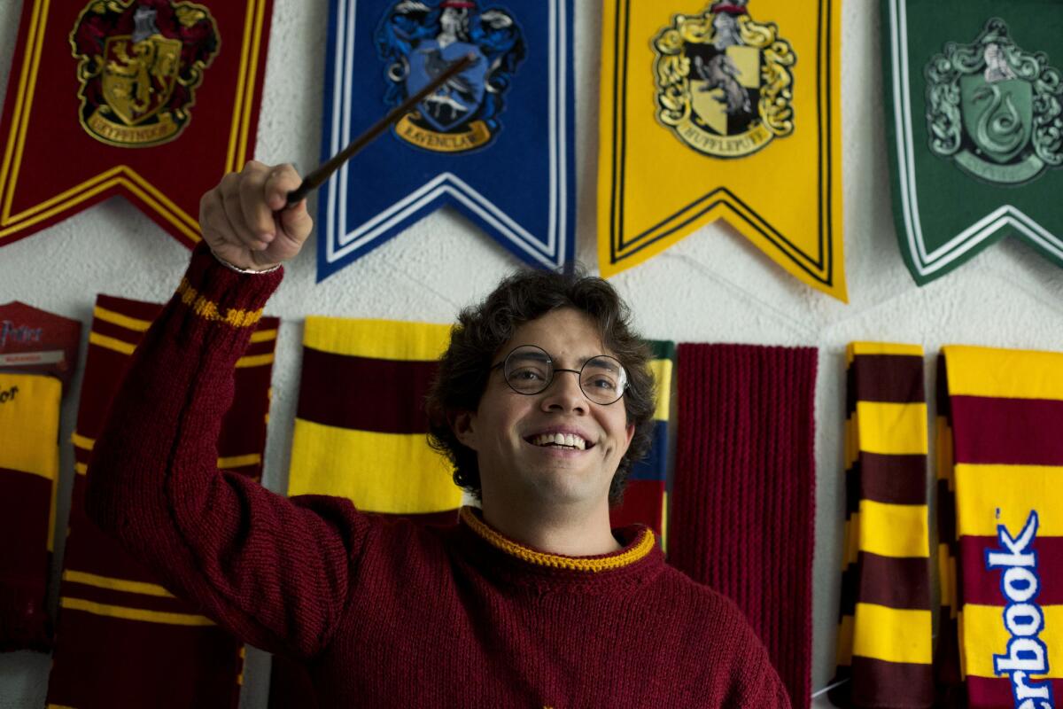 Menahem Asher Silva Vargas with a Harry Potter wand, glasses, scarves and more, part of his Guinness world record-setting collection of Harry Potter memorabilia.
