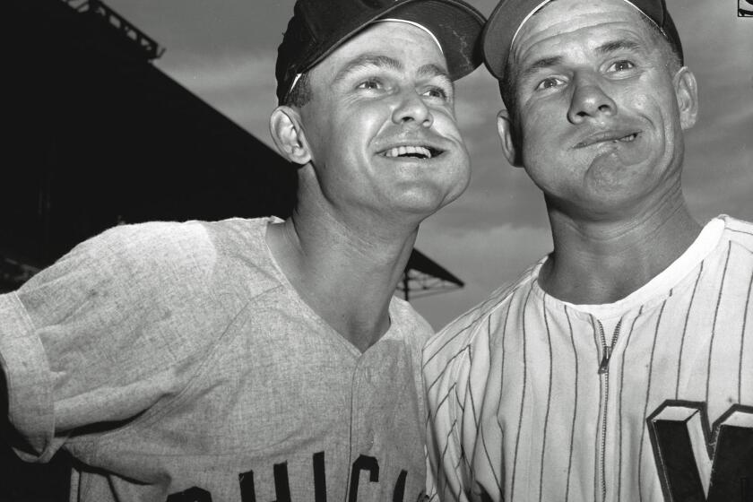 Chicago White Sox second baseman Nellie Fox, left, and Washington Senators shortstop Rocky Bridges pose with bulging wads of chewing tobacco before a game at Washington on Aug. 1, 1957. A California lawmaker wants to ban chewing tobacco from all levels of organized baseball in the state.