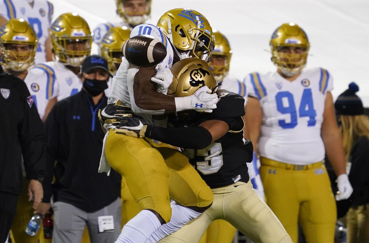 UCLA running back Demetric Felton can't make a catch as he is hit by Colorado safety Isaiah Lewis.