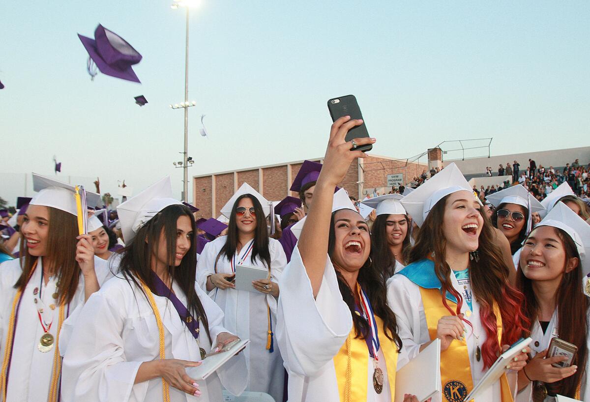 Graduates take selfies, cheer, and throw caps in the air at the conclusion of graduation of Hoover High School in Glendale on Wednesday, June 1, 2016.