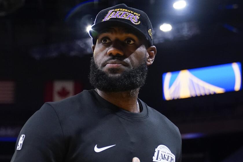 Los Angeles Lakers forward LeBron James stands on the court before a basketball game.