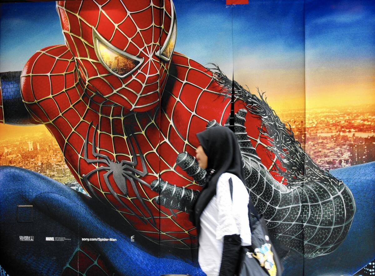 A woman walks past a "Spider-Man 3" poster in Hong Kong in 2007.