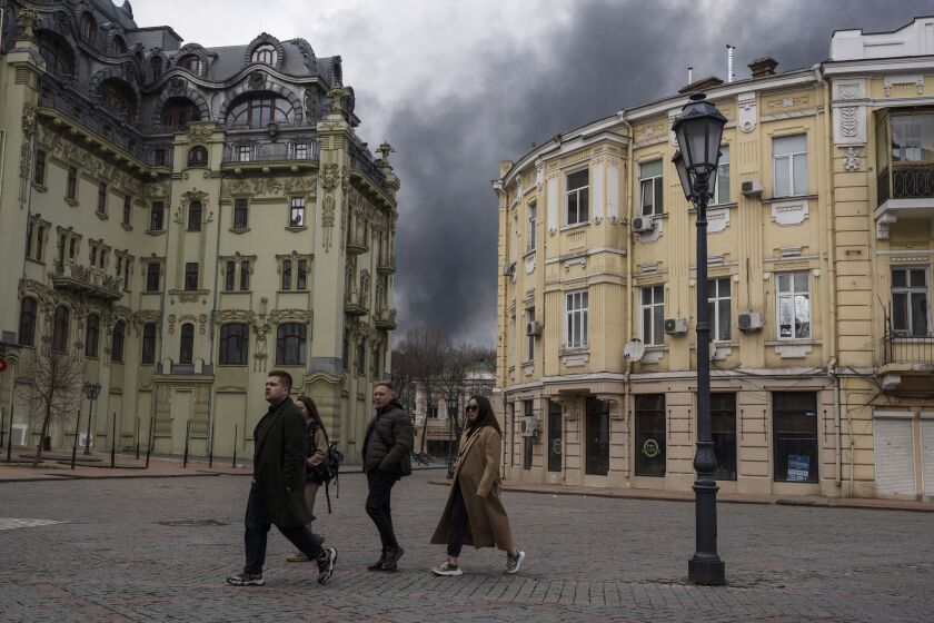 FILE - People walk in a street as smoke rises in the air after shelling in Odesa, Ukraine, Sunday, April 3, 2022. The United Nations' cultural agency decided on Wednesday Jan.25, 2023 to add the historic center of Ukraine's Black Sea port city of Odesa to the list of World Heritage in danger. The decision was made at an extraordinary session of the World Heritage Committee in Paris.AP Photo/Petros Giannakouris, File)