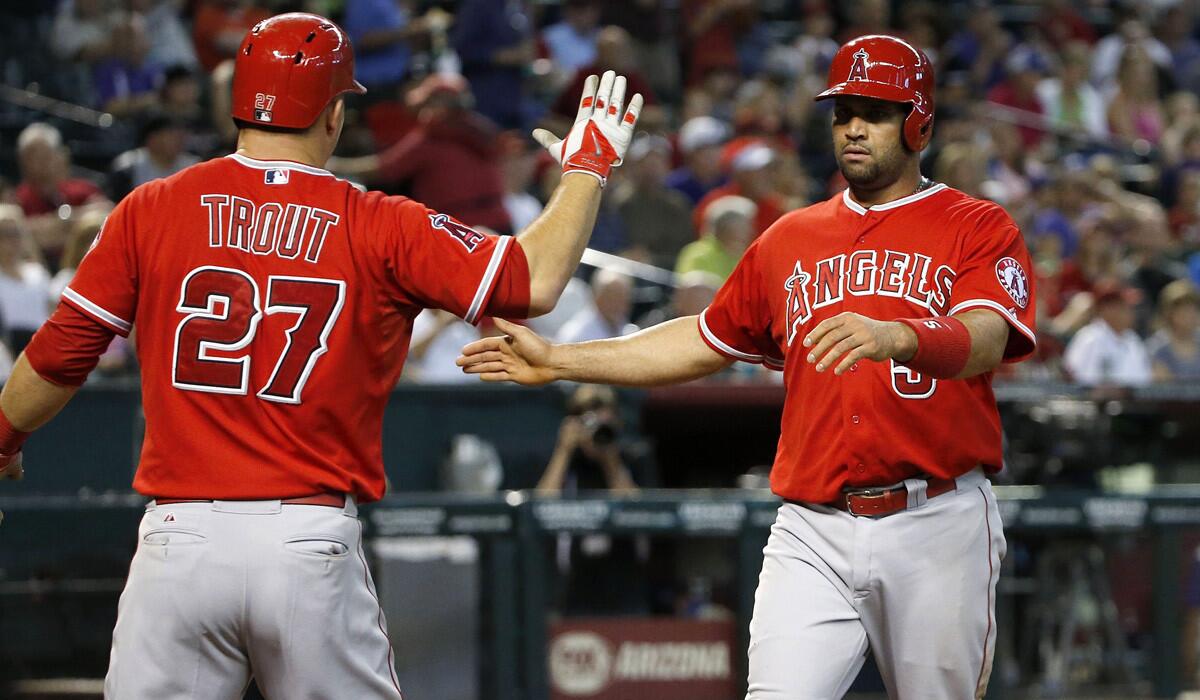 Los Angeles Angels' Mike Trout and Albert Pujols celebrate after both scoring runs against the Arizona Diamondbacks during the sixth inning on Thursday.