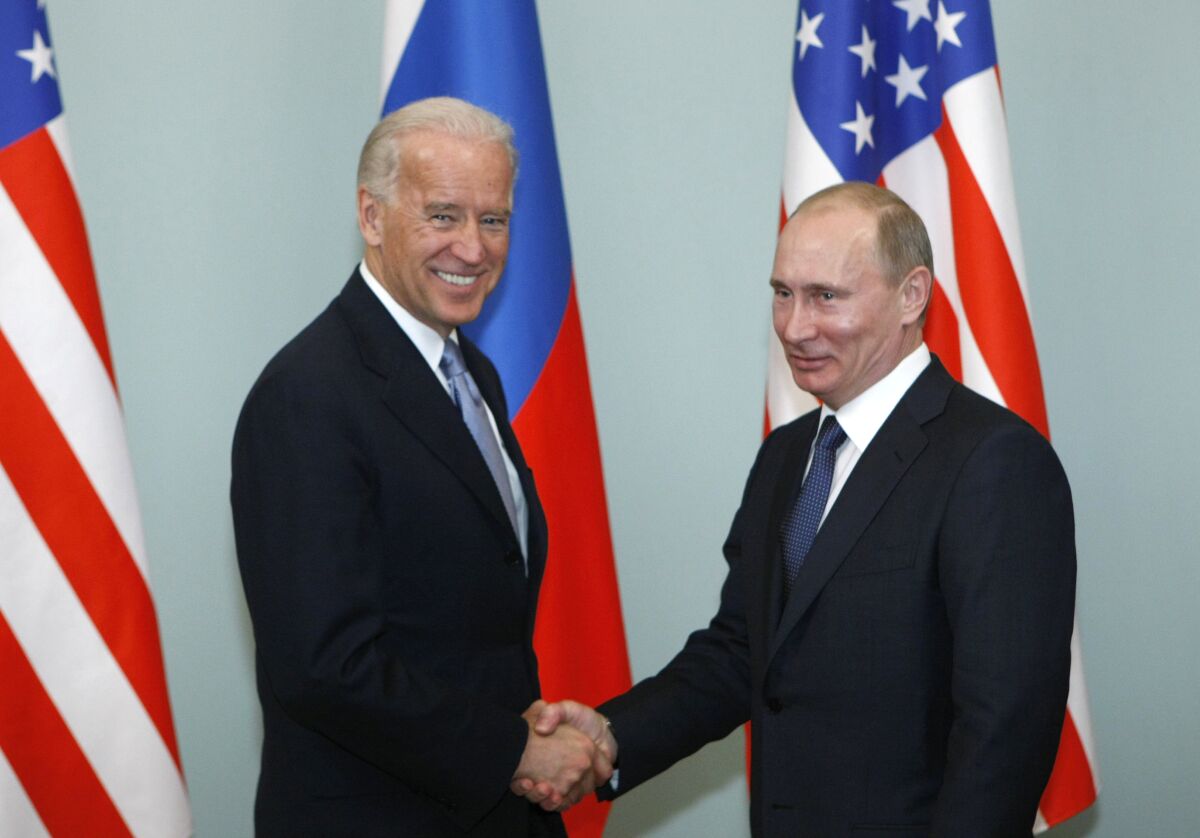 Then-Vice President Joe Biden shakes hands with then-Prime Minister Vladimir Putin of Russia in Moscow on March 10, 2011. 