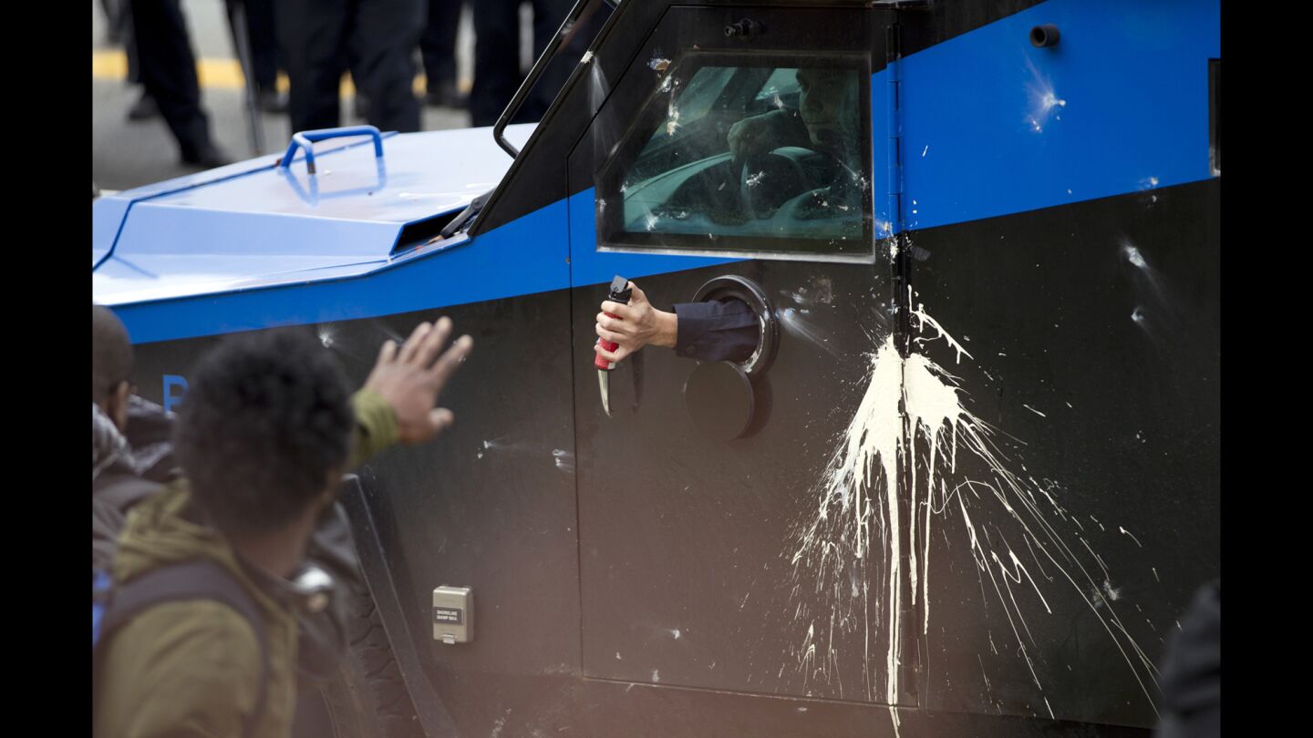 A Baltimore police officer aims pepper spray at demonstrators after the funeral of Freddie Gray on Monday. Gray, 25, died April 19 after suffering a fatal spinal injury while in police custody.