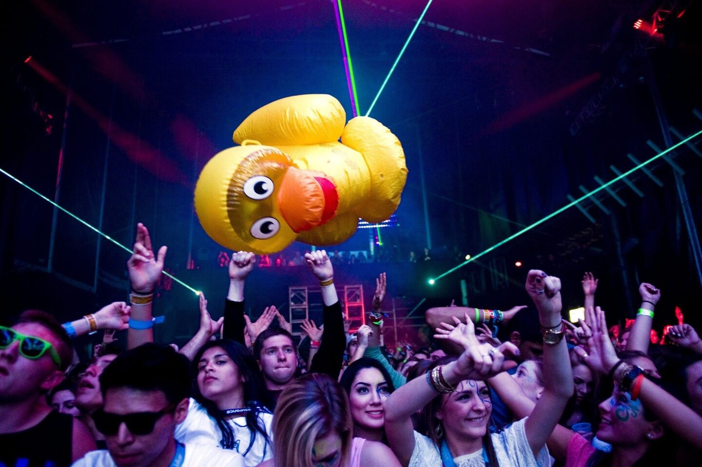 A giant inflatable duck is batteed around by fans as the Los Angeles-based hip-hop band Far East Movement performs at the Doritos' Bold Stage.