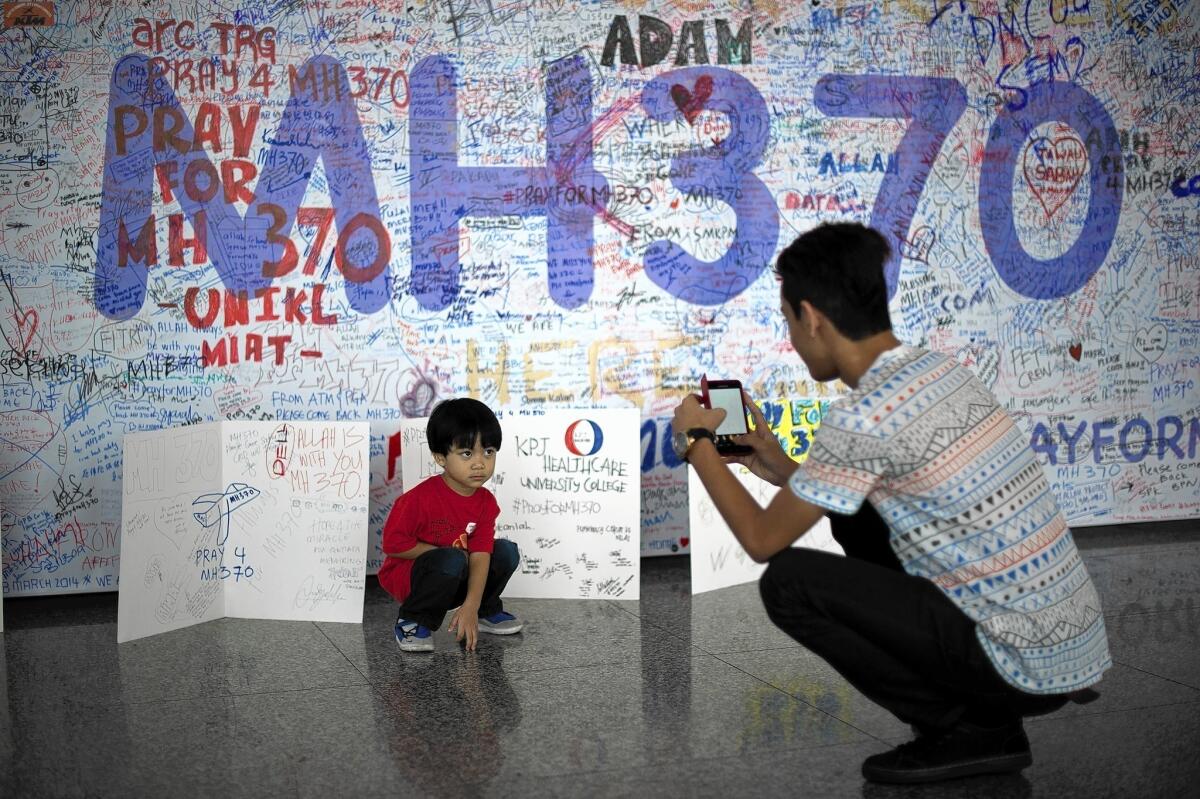 A visitor at Kuala Lumpur International Airport photographs messages for the passengers aboard the missing Malaysia Airlines flight.