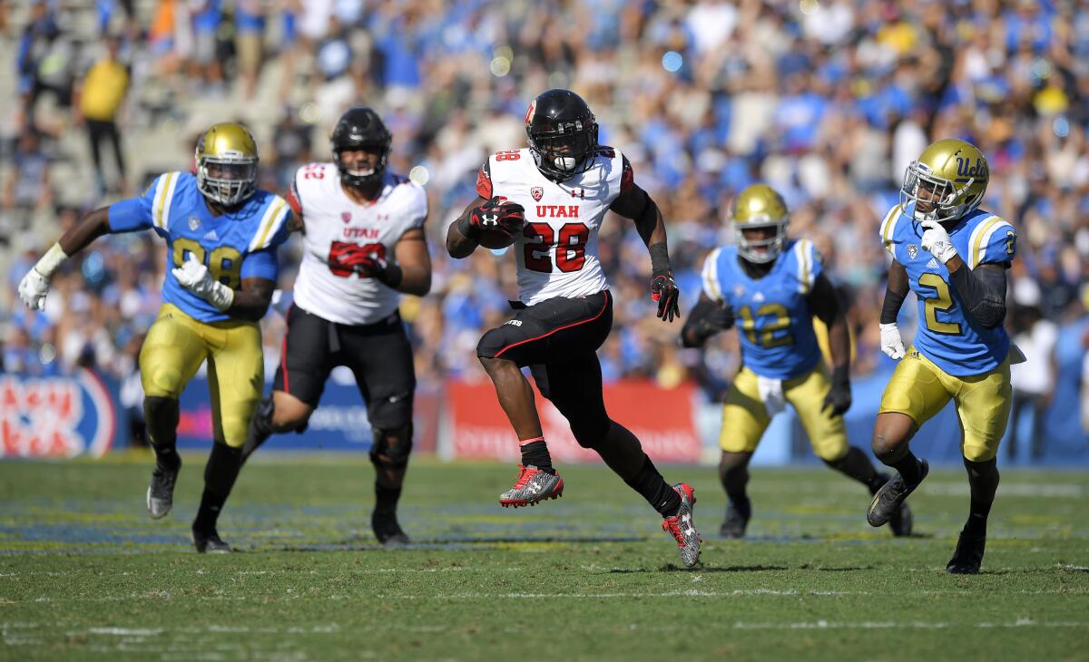 Utah running back Joe Williams runs for a touchdown as UCLA defenders chase him