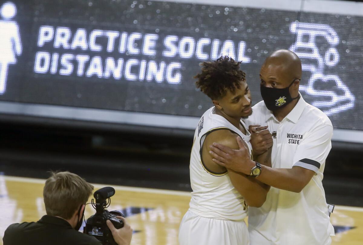 Interim Wichita State head coach Isaac Brown, right, congratulates Tyson Etienne after Etienne scored 26 points in a 85-50 win over Oral Roberts Wednesday, Dec. 2, 2020 in Wichita, Kan. (Travis Heying/The Wichita Eagle via AP)