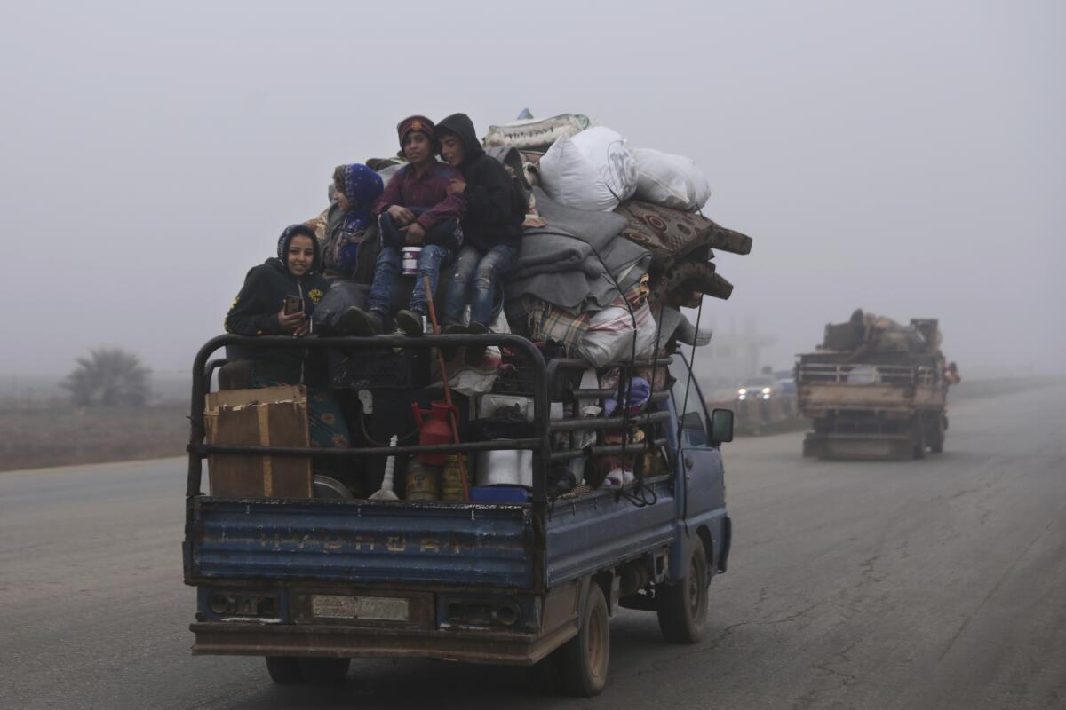 Civilians ride in a truck on Monday as they flee Maaret al-Numan, Syria, ahead of a government offensive.