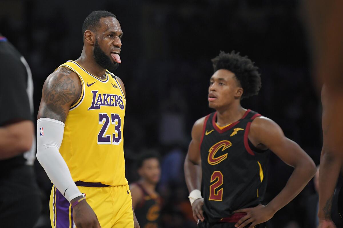 Los Angeles Lakers forward LeBron James, left, sticks his tongue out after scoring and drawing a foul as Cleveland Cavaliers guard Collin Sexton looks on during the second half of an NBA basketball game, Monday, Jan. 13, 2020, in Los Angeles. The Lakers won 128-99. (AP Photo/Mark J. Terrill)