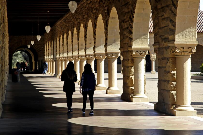 Students walk on the Stanford University campus in Stanford, Calif. in 2019.