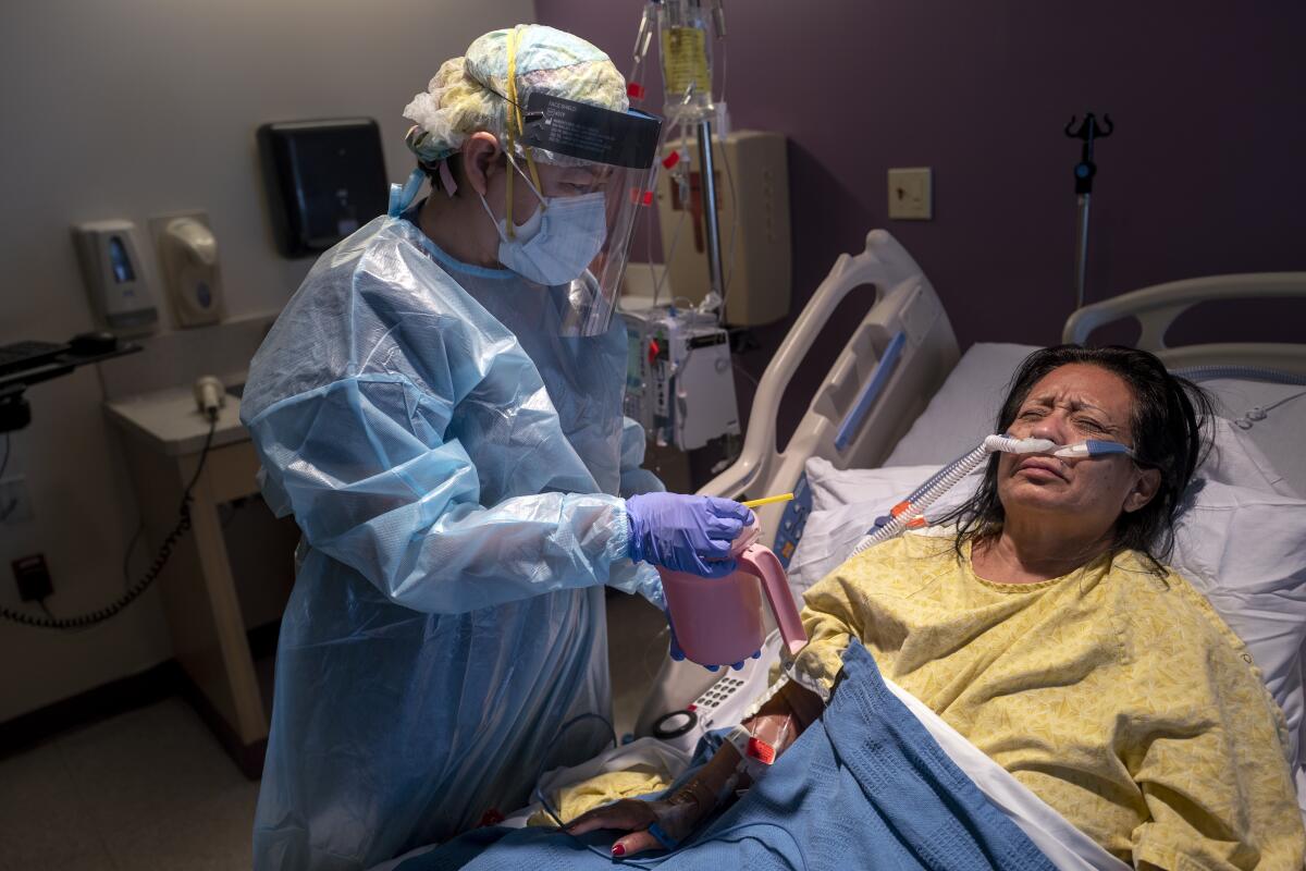 A nurse helps a hospitalized patient sip water