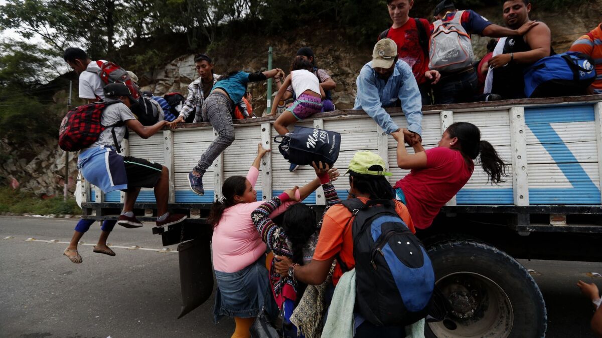 Honduran immigrants who are traveling north in a large caravan board trucks in Zacapa, Guatemala, on Oct. 17, 2018.