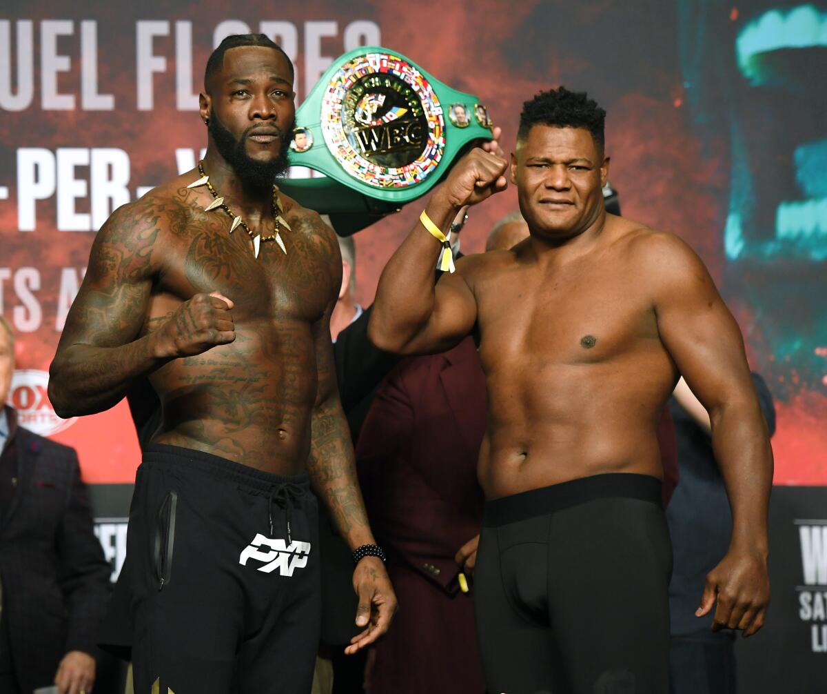 WBC heavyweight champion Deontay Wilder, left, and Luis Ortiz pose during their official weigh-in at MGM Grand Garden Arena on Friday in Las Vegas.